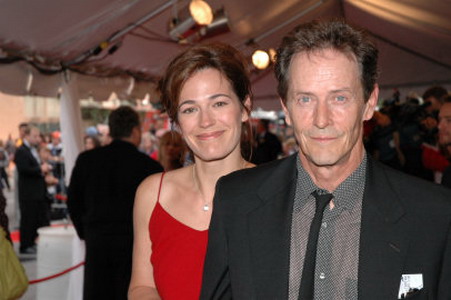 Stephen McHattie and Lisa Houle together at a party. Lisa is in red while Stephen is wearing a suit.